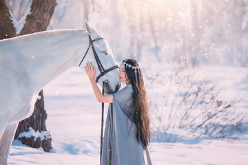 cute elf princess in long gray cloak and vintage dress, girl with long black wavy curly hair stands...