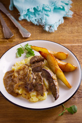 Liver with pears and cream and wine onion sause on mashed potato. vertical