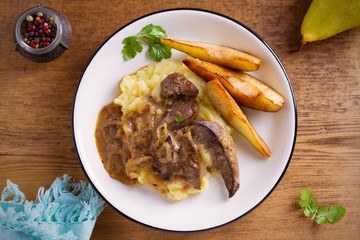 Liver with pears and cream and wine onion sause on mashed potato. overhead, horizontal