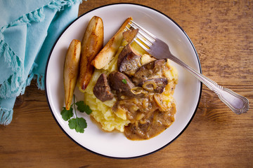 Liver with pears and cream and wine onion sause on mashed potato. overhead, horizontal