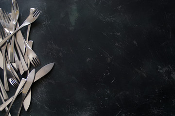 Cutlery on the left of a dark wooden background menu
