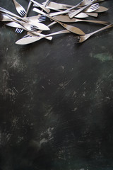 Cutlery on dark wooden background. Empty space