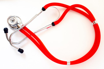 Red and black stethoscope on white background open area in middle of loop on right