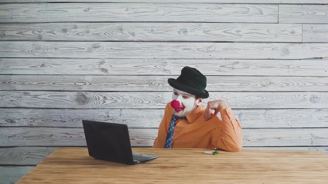 Office worker clown, clown concept at work. Businessman at the computer, work on a laptop.