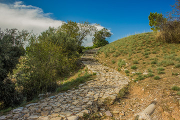 spring colorful park outdoor natural environment for walking and promenade with narrow paves and curved stone road through hill scenery landscape space