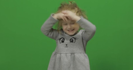 Kid girl on a Green Screen, Chroma Key. Happy three years old girl