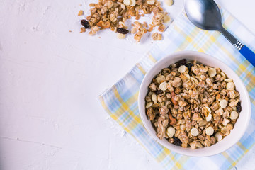 Organic granola with fresh berries and cashew nuts on white background flat lay.