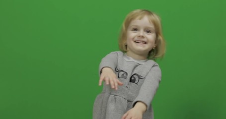 Kid girl on a Green Screen, Chroma Key. Happy three years old girl