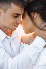 Close-up photo of loving couple. The guy gently hugs his beloved girlfriend