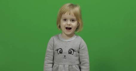 Kid girl on a Green Screen, Chroma Key. Happy three years old girl