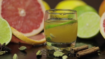 Lime slice falls into a glass cup with an alcoholic cocktail