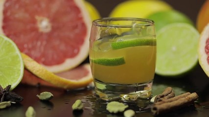 Lime slice falls into a glass cup with an alcoholic cocktail