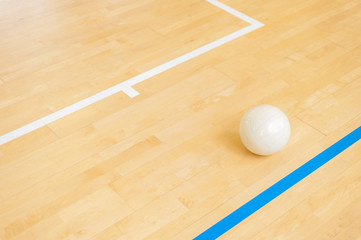 White volleyball on the ground in the school gym