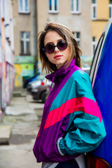 woman in jacket of 90s style stay at counrtyard of house