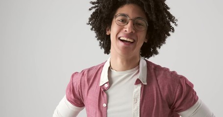Handsome man with curly hair laughing over white background