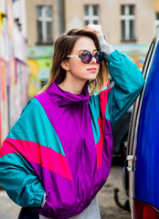 woman in jacket of 90s style stay at counrtyard of house