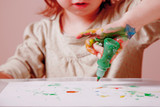 Cute little child girl painting with colorful hands. Happy childhood, art, drawing concept.
