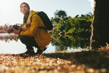 Tourist sitting near a lake with a dslr camera