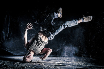 cool dirty vietnamese  guy dancer in style of bboying doing complex tricks on floor in Studio...