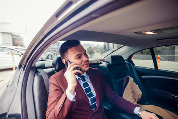 Suit man driving in a luxury car