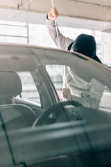 Male car thief open door with jemmy