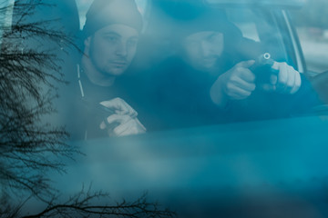 Thieves parked in an ally waiting and planning the way they will rob their target.