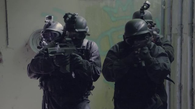 A Special Force Team walk through a open corridor.