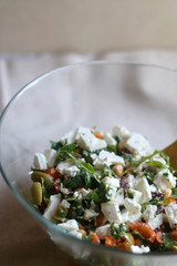 Salad with various vegetables (spinach, olives, tomatoes, carrot, parsley), feta cheese, chickpeas and beans. Selective focus. 