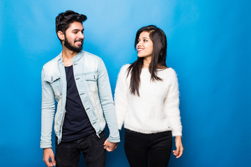 Young indian couple standing isolated on blue background