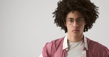 Handsome man with curly hair giving suspicious look