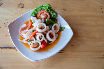 Thai style spicy minced squid salad, North Eastern of Thailand's famous menu. Thai-delicious Steamed Sweet, Sour & Spicy Squid in lime sauce with squid's eggs. Traditional Thai salad with squid.
