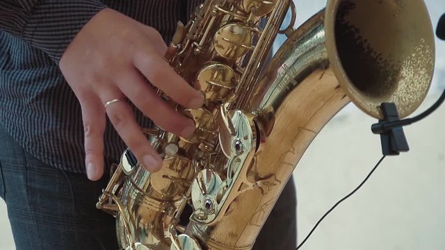Saxophonist plays the saxophone. Slow motion. Close up