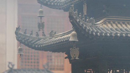 Immortal and beasts on the eaves of the building in Shanghai Jingan temple, Imperial yellow roof decorations, Wind bells under eaves sway with the wind, high speed video, slow motion.