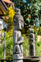 Balinese ancient wooden statue on street in Ubud, island Bali, Indonesia. These figures of the gods protect the house from evil spirits. Closeup