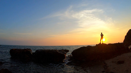Silhouette of the man selfie in the sea at sunset