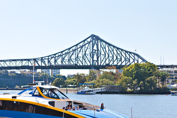 Long metal bridge and a  boat on the river water