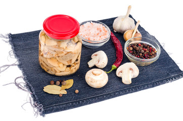 Jar of pickled mushrooms, champignon, spices, onion, garlic for pickling.