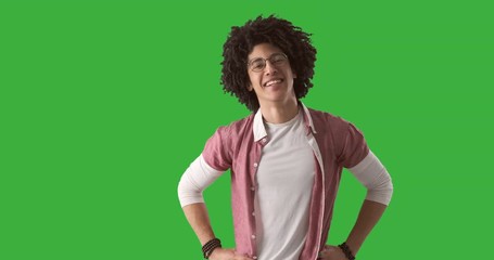Portrait confident young man with curly hair smiling over green background
