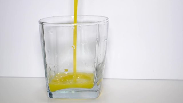 Pouring a glass of orange juice in slow motion