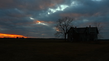 silhouette of tree and old house at sunset