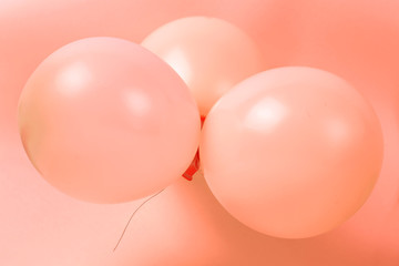 Three Balloons on a coral background close-up, holiday concept