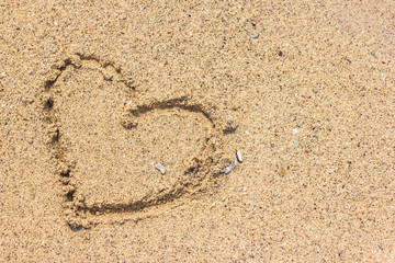 Heart shape drawn on sand at the beach