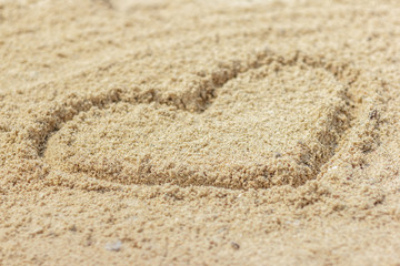 Fototapeta na wymiar Heart shape drawn on sand at the beach