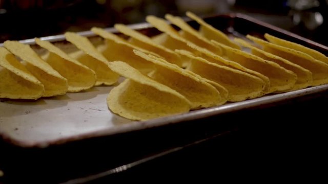 Taco night hard shell tortilla tacos ready to be dressed and prepared for homemade Mexican food. Empty yellow taco shells close up. Food and drink concept.