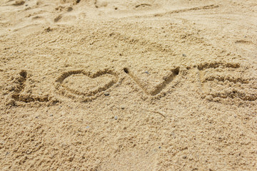 Love word written on the sand at the beach, natural background of love symbol