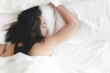 Obraz na płótnie Canvas Woman has a deep sleep on white bed. Concept of tried and rest.