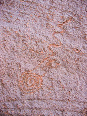 Ancient prehistoric petroglyph of spiral on red rock   southern Utah