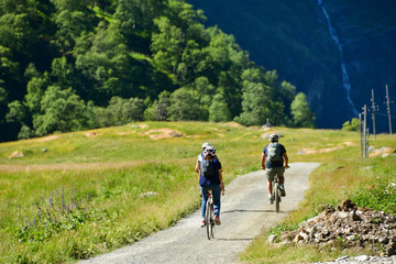 people ride bicycle on mountain road at flam Norway