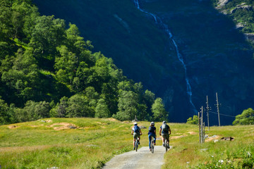 people ride bicycle on mountain road at flam Norway