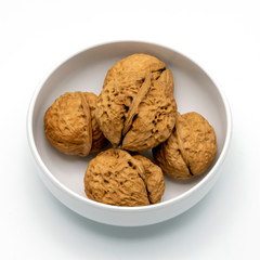 The Walnuts in White Bowl Isolated on a White Background.